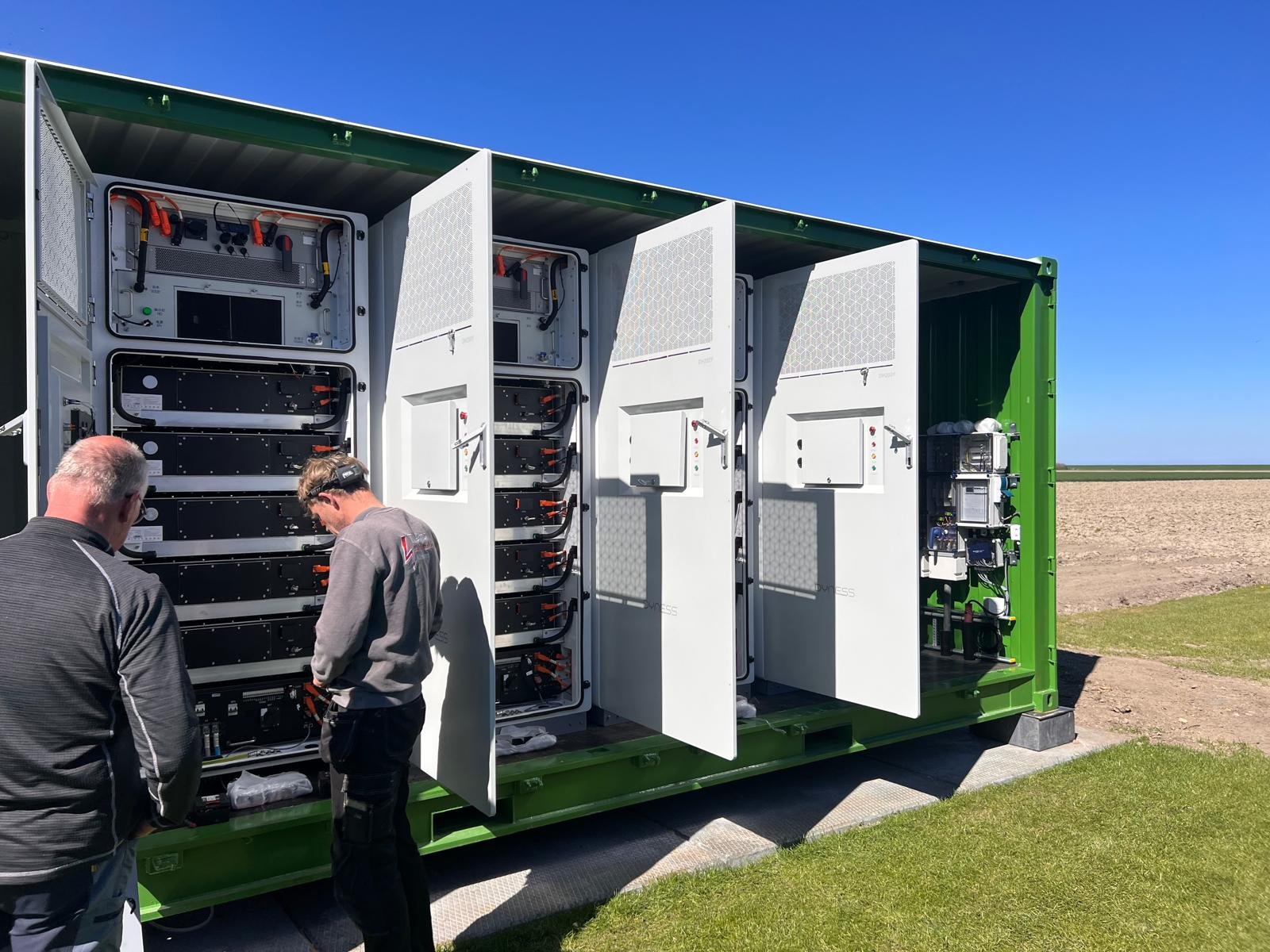 Twee BessQ-monteurs bij een geopende batterijcontainer